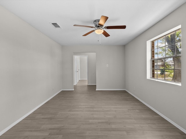 empty room with ceiling fan and light hardwood / wood-style flooring