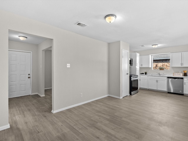 kitchen featuring white cabinets, appliances with stainless steel finishes, light hardwood / wood-style flooring, and sink