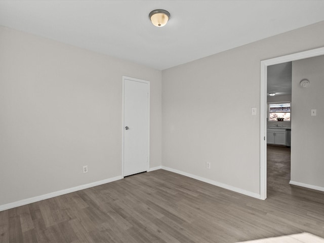 empty room with hardwood / wood-style flooring and sink