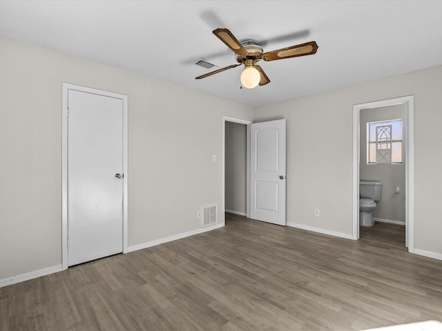 unfurnished bedroom with hardwood / wood-style flooring, ceiling fan, connected bathroom, and a closet