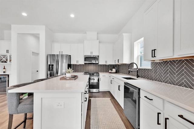 kitchen with white cabinetry, sink, a kitchen island, and stainless steel appliances