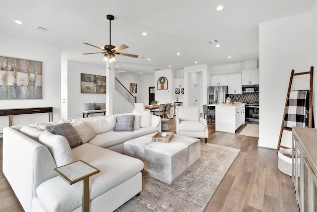 living room with light wood-type flooring and ceiling fan