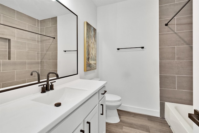 full bathroom with vanity, wood-type flooring, tiled shower / bath combo, and toilet