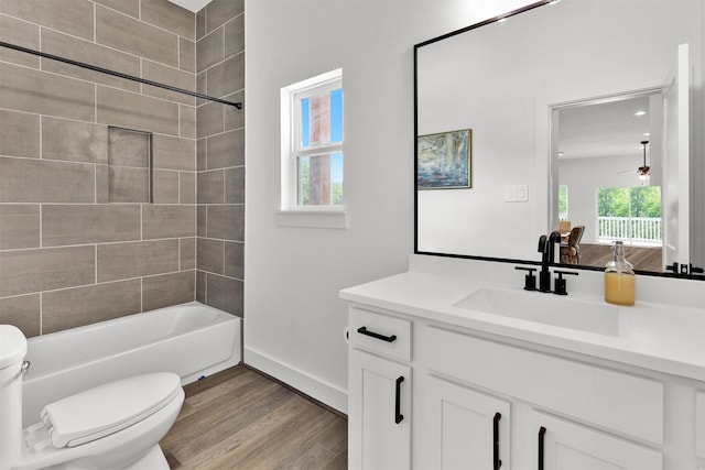 full bathroom featuring ceiling fan, tiled shower / bath combo, toilet, vanity, and hardwood / wood-style flooring