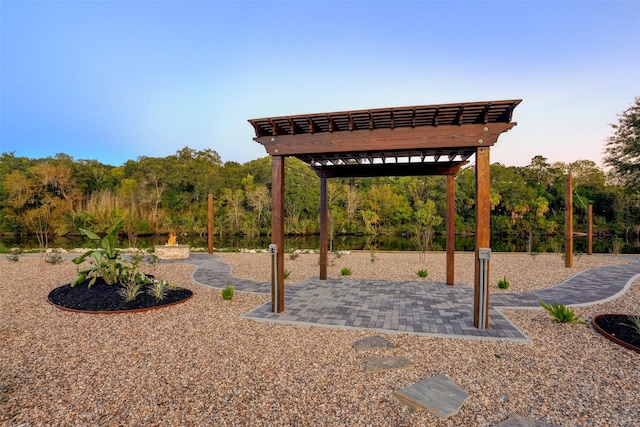 yard at dusk featuring a pergola