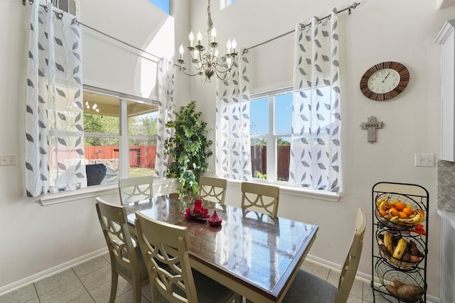 tiled dining room featuring a wealth of natural light and a chandelier