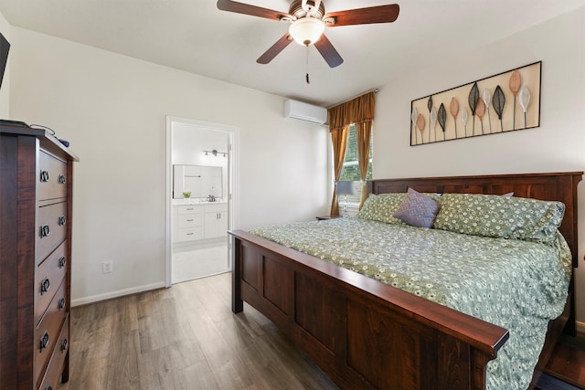 bedroom with ensuite bath, ceiling fan, sink, dark hardwood / wood-style flooring, and an AC wall unit