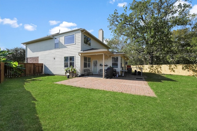 back of house featuring a lawn and a patio