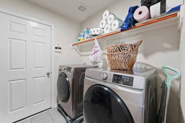 laundry area featuring separate washer and dryer and light tile patterned flooring