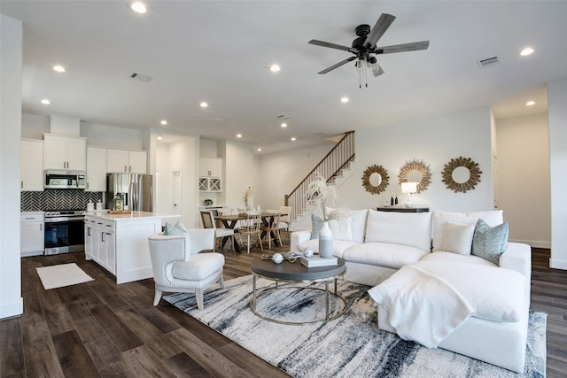 living room with ceiling fan and dark wood-type flooring