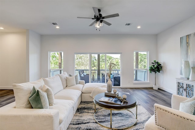 living room featuring ceiling fan, a healthy amount of sunlight, and dark hardwood / wood-style floors