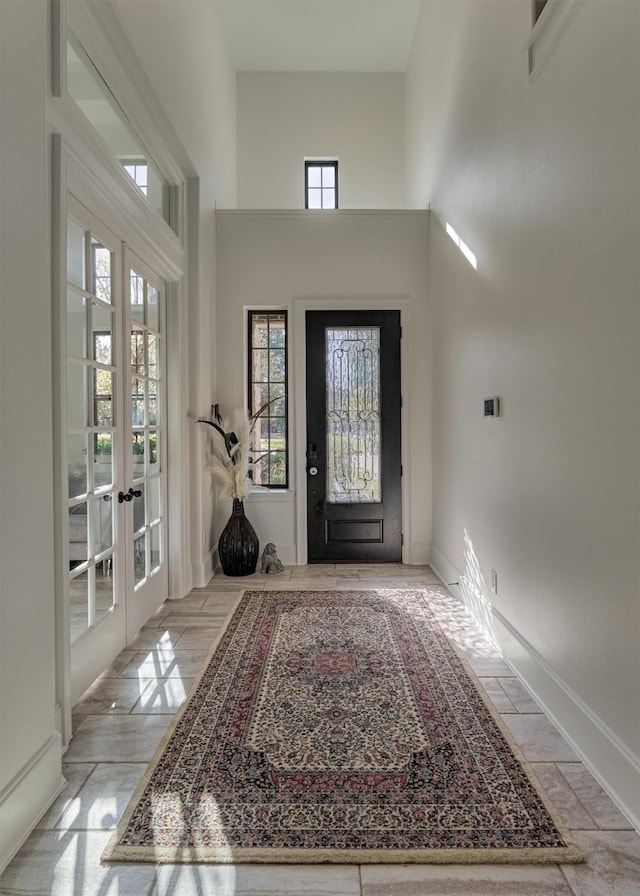 foyer entrance with a high ceiling and french doors