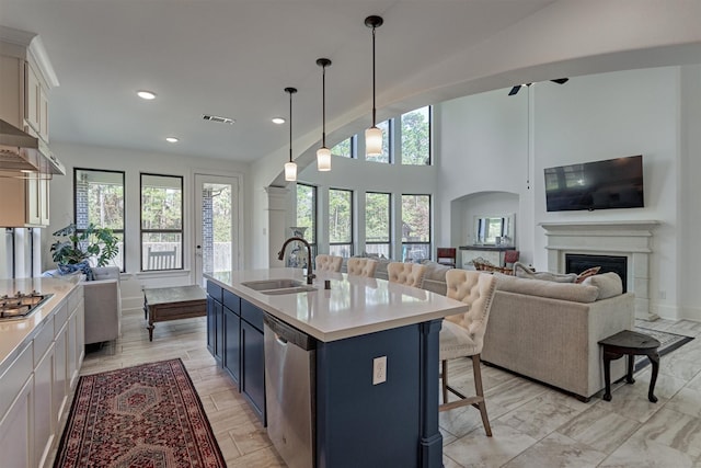 kitchen featuring sink, white cabinetry, a breakfast bar area, a kitchen island with sink, and appliances with stainless steel finishes