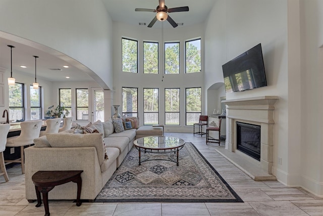 living room featuring a high ceiling, ceiling fan, and a wealth of natural light