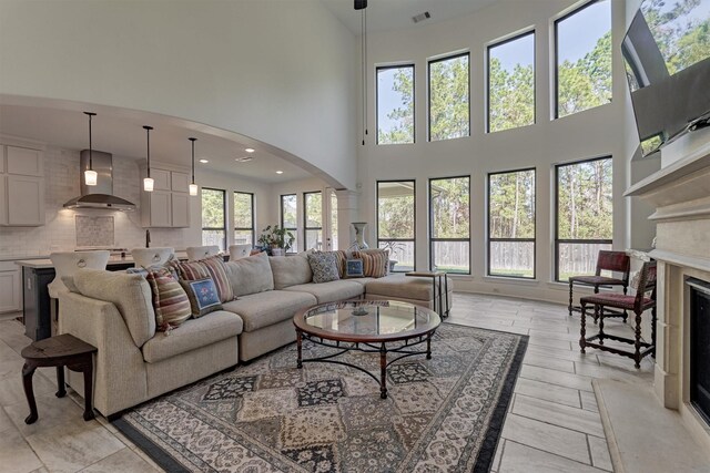 living room featuring a towering ceiling and a high end fireplace