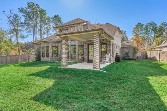 back of property with a patio, central AC unit, and a yard