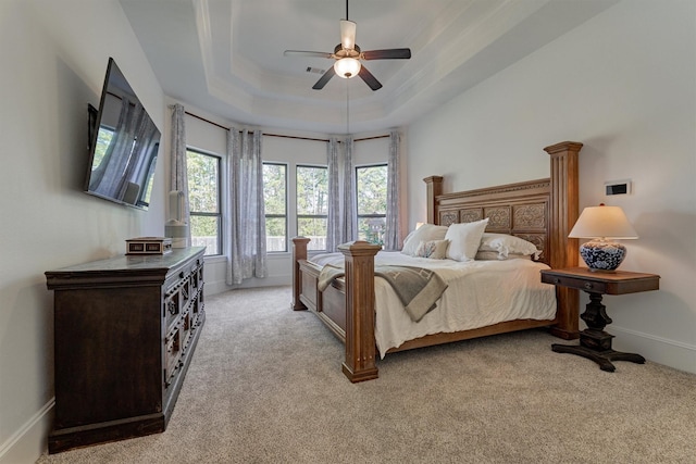 bedroom featuring ornamental molding, a raised ceiling, ceiling fan, and light carpet