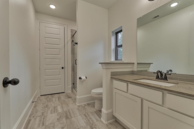 bathroom featuring toilet, an enclosed shower, and vanity