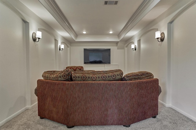 carpeted cinema featuring ornamental molding and a raised ceiling