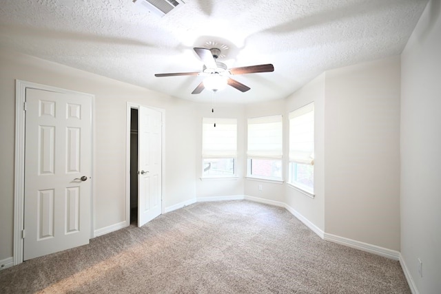 carpeted empty room with a textured ceiling and ceiling fan