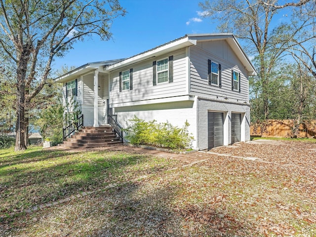 view of front of property featuring brick siding, driveway, and an attached garage