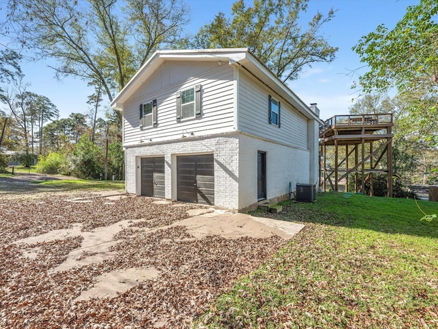 view of side of property with a garage, a wooden deck, dirt driveway, a yard, and brick siding