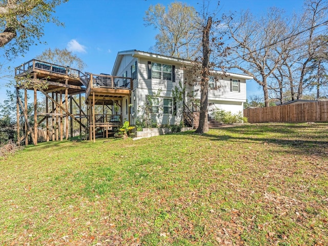 back of house with stairway, fence, a deck, and a lawn