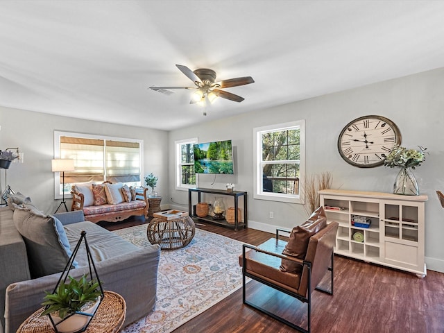 living area with a ceiling fan, baseboards, and wood finished floors