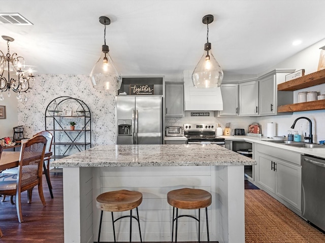 kitchen featuring open shelves, stainless steel appliances, visible vents, a sink, and wallpapered walls