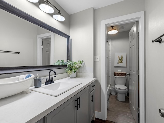 full bathroom with visible vents, vanity, toilet, and wood finished floors