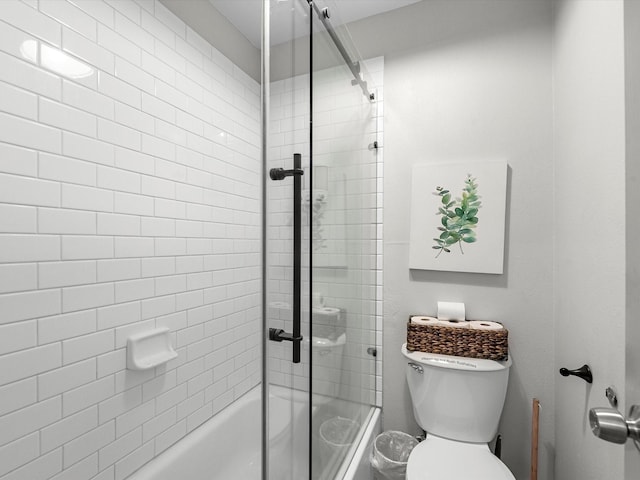 bathroom featuring combined bath / shower with glass door and toilet