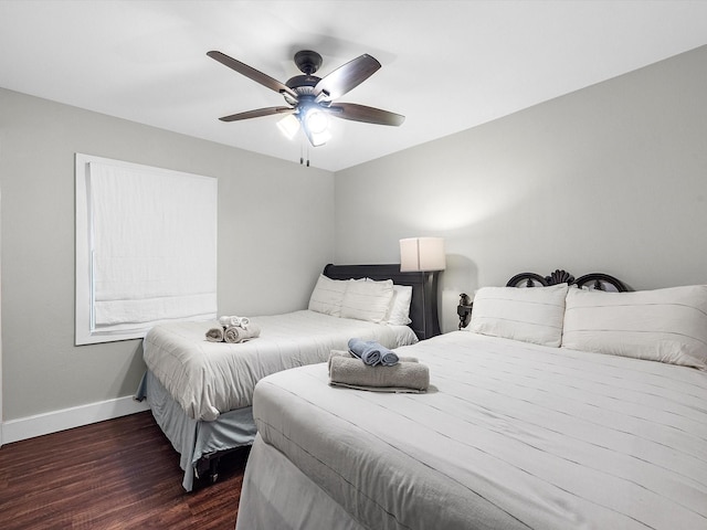 bedroom with ceiling fan, baseboards, and dark wood finished floors