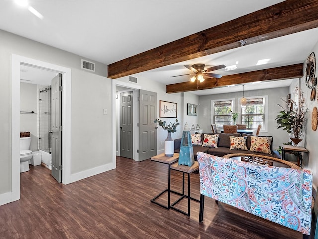 living room featuring beamed ceiling, ceiling fan, and dark wood-type flooring