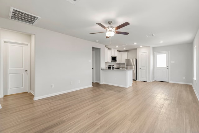 unfurnished living room featuring ceiling fan and light wood-type flooring