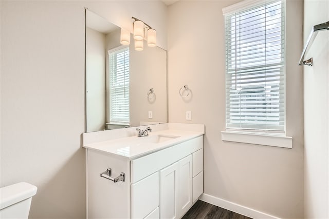 bathroom with vanity, toilet, and wood-type flooring