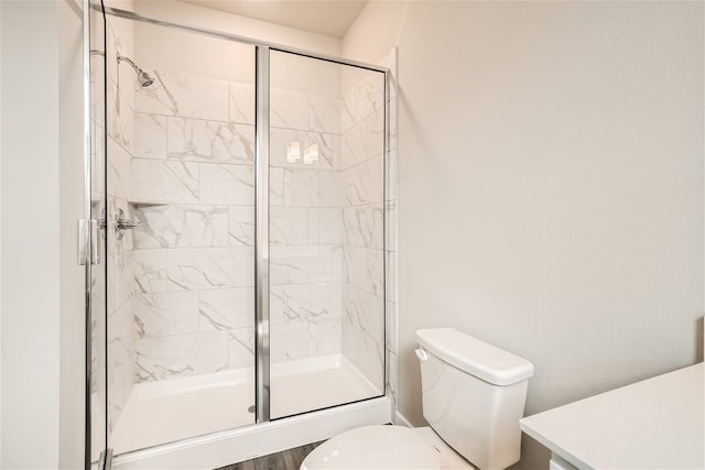 bathroom featuring hardwood / wood-style flooring, toilet, and walk in shower