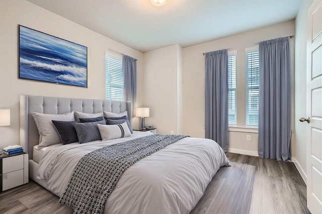 bedroom with hardwood / wood-style flooring and multiple windows