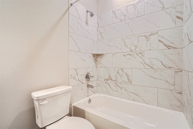 bathroom featuring tiled shower / bath and toilet