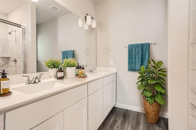 bathroom featuring vanity, wood-type flooring, and walk in shower