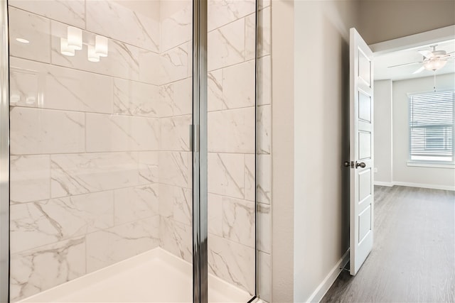 bathroom featuring hardwood / wood-style flooring, a shower with door, and ceiling fan