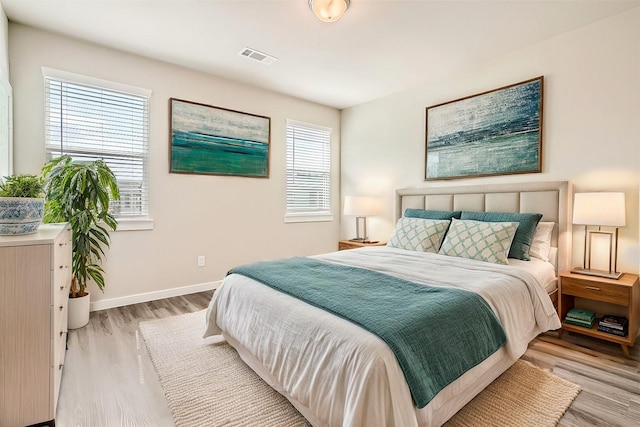 bedroom featuring multiple windows and light hardwood / wood-style flooring