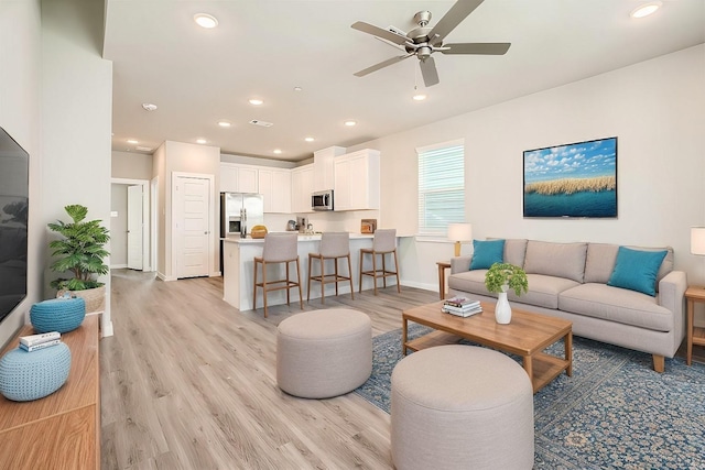 living room featuring ceiling fan and light wood-type flooring