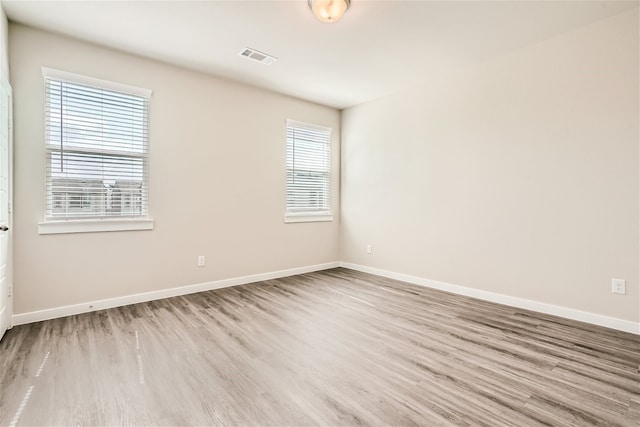 spare room with a wealth of natural light and light hardwood / wood-style flooring