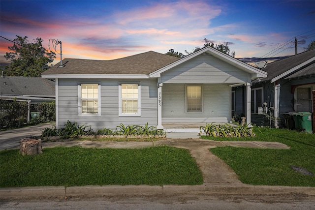 bungalow-style house with covered porch and a yard