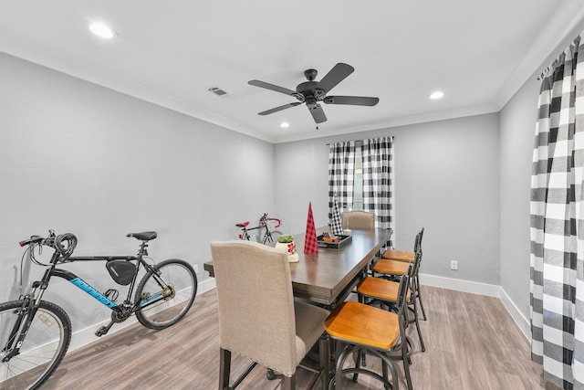 dining area with hardwood / wood-style flooring, ceiling fan, and ornamental molding