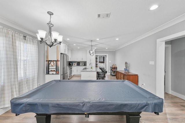 rec room with light wood-type flooring, sink, pool table, and a chandelier