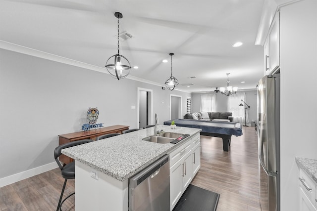 kitchen featuring light stone countertops, sink, stainless steel appliances, an island with sink, and white cabinets