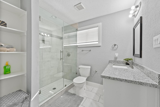 bathroom with tile patterned floors, walk in shower, a textured ceiling, vanity, and toilet