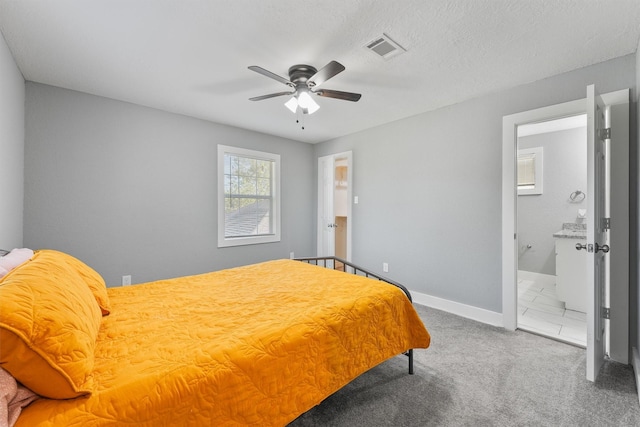 carpeted bedroom featuring ensuite bath and ceiling fan