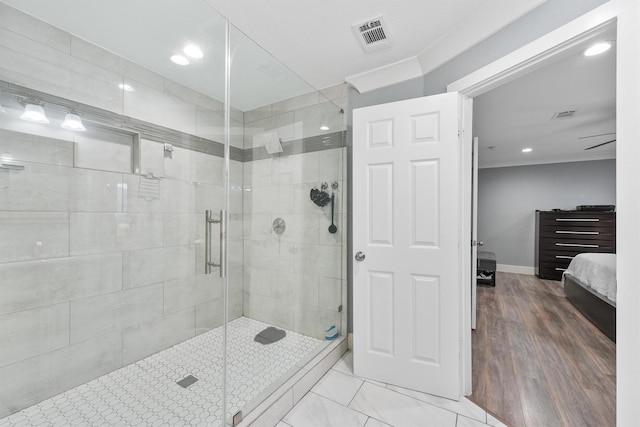 bathroom with hardwood / wood-style floors, an enclosed shower, and ornamental molding